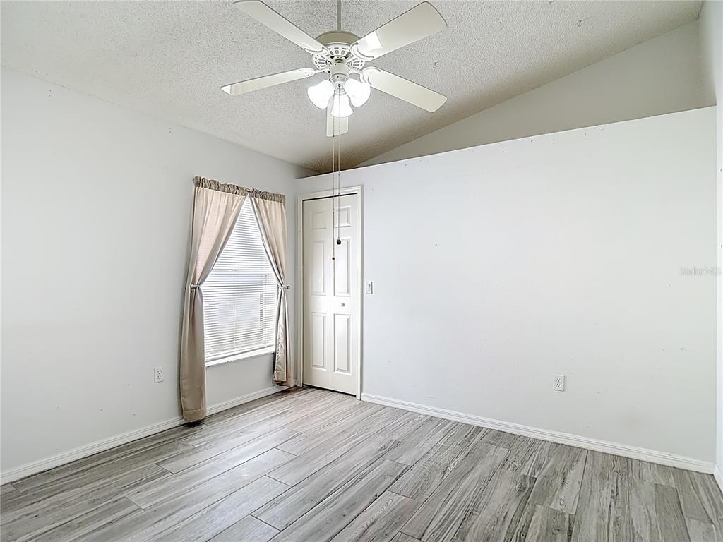 280 Quane Avenue Spring Hill, FL 34609 - Photo 37 of 62 an empty room with wooden floor chandelier fan and windows