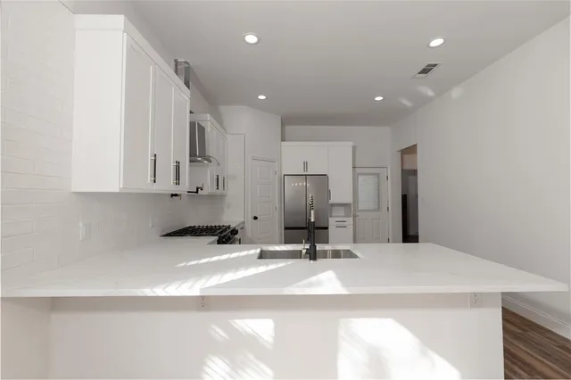 a kitchen with kitchen island a sink stainless steel appliances and cabinets