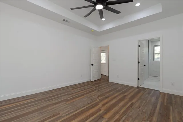 an empty room with a window and a ceiling fan