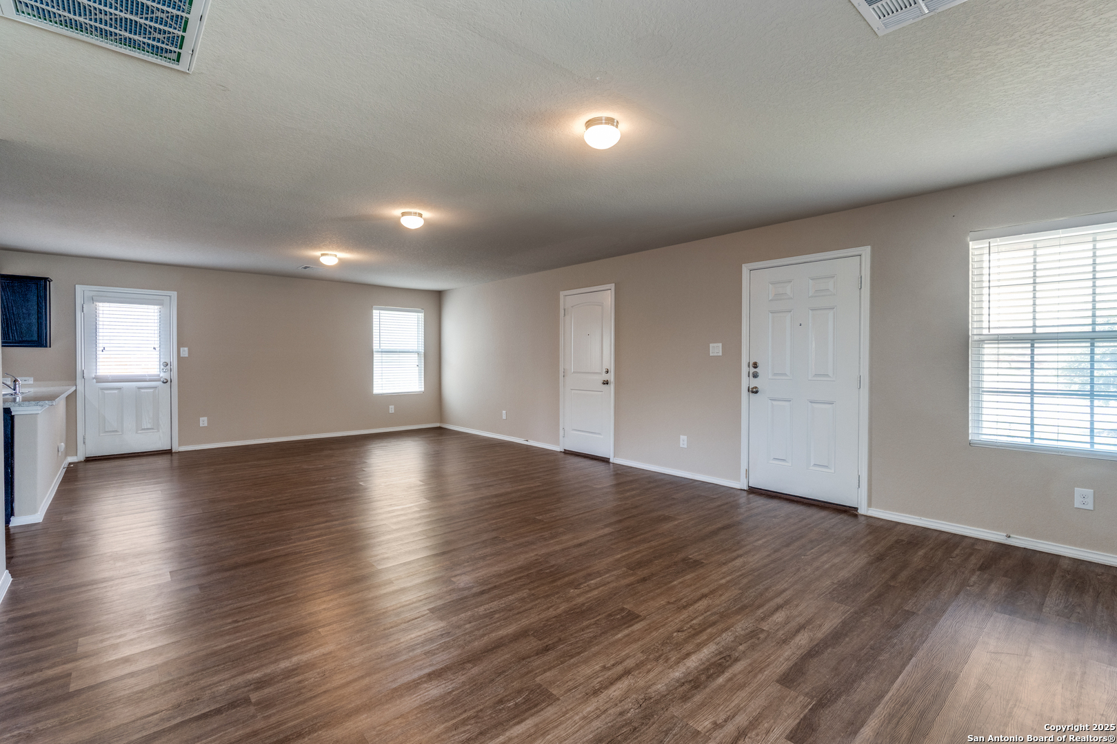 5102 Everett Loop Converse, TX 78109 - Photo 7 of 24 an empty room with wooden floor and windows
