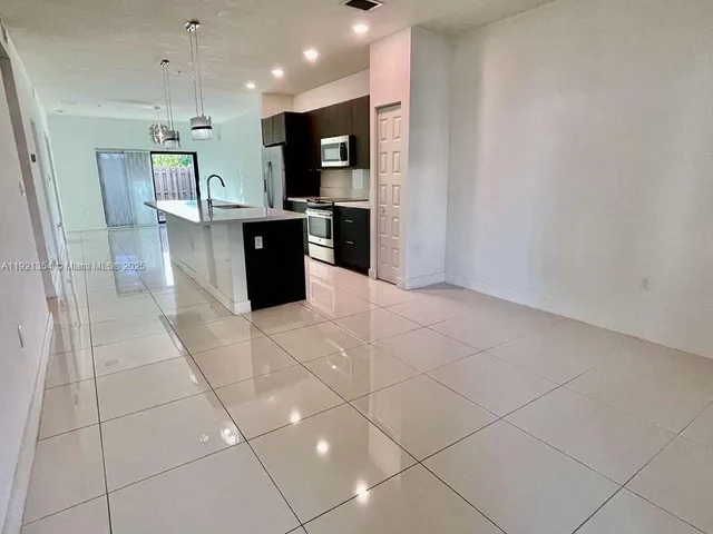 a large kitchen with kitchen island granite countertop a large counter top and appliances