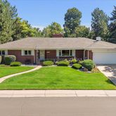 a front view of a house with a garden and trees