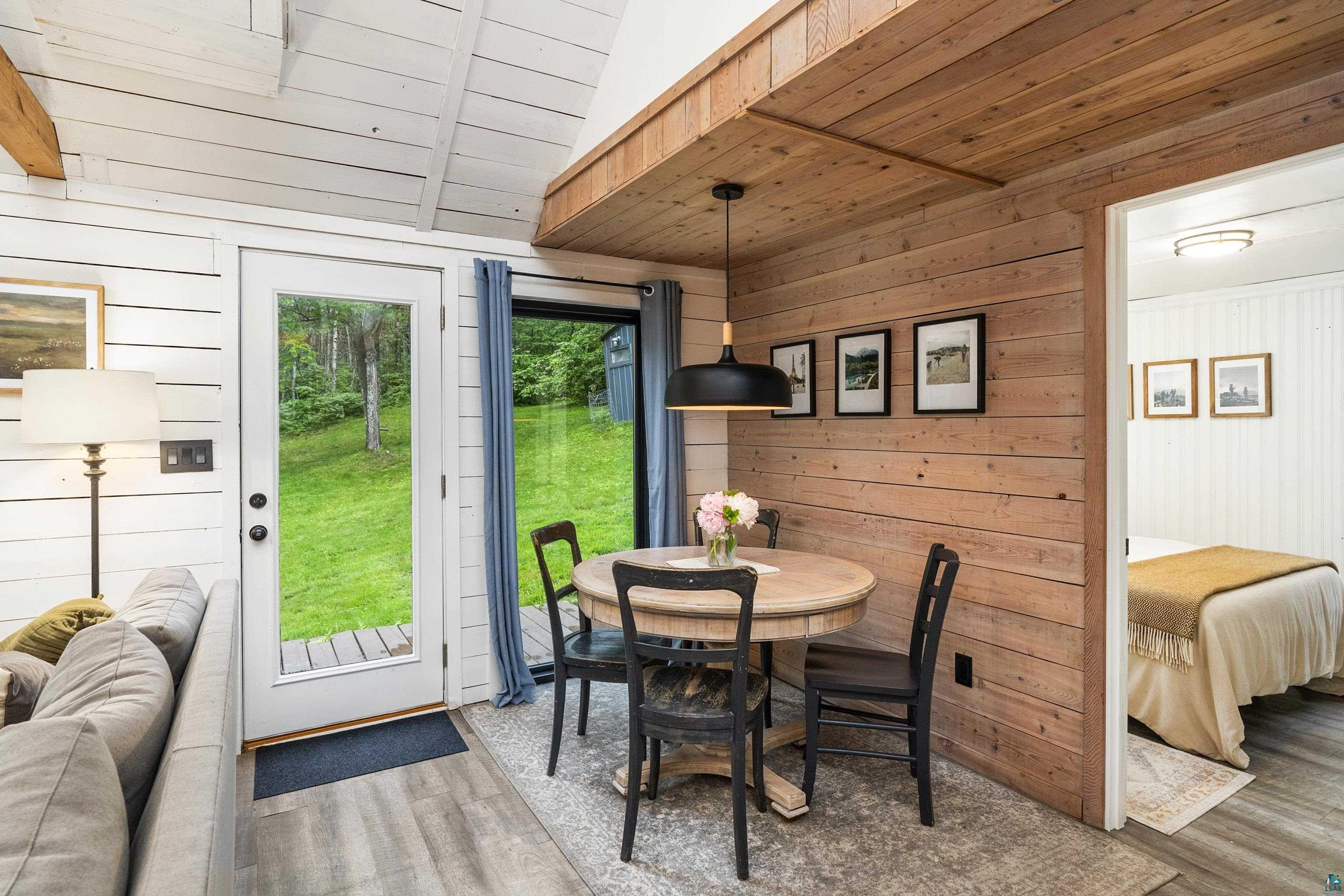 6345 Smith Lake Road Barnes, WI 54873 - Photo 14 of 50 Dining area with wooden walls, vaulted ceiling, hardwood / wood-style floors, and wood ceiling