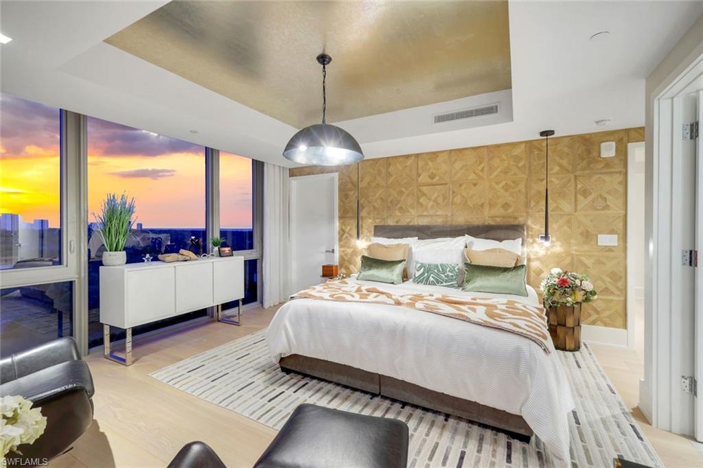 6897 Grenadier Boulevard, Unit 601 Naples, FL 34108 - Photo 27 of 48 a bedroom with a large bed and a glass window