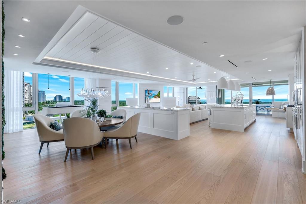 6897 Grenadier Boulevard, Unit 601 Naples, FL 34108 - Photo 3 of 48 a living room with furniture a wooden floor and a kitchen view