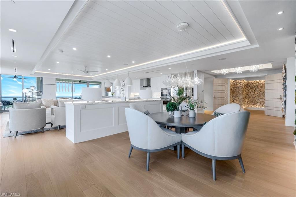 6897 Grenadier Boulevard, Unit 601 Naples, FL 34108 - Photo 7 of 48 a view of a dining room with furniture and wooden floor
