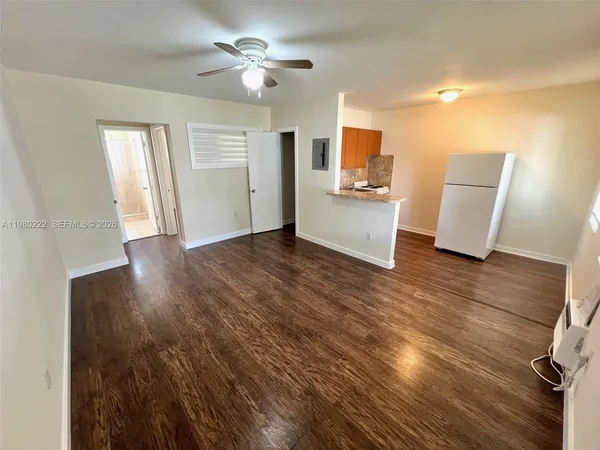 a view of a kitchen with wooden floor and a ceiling fan