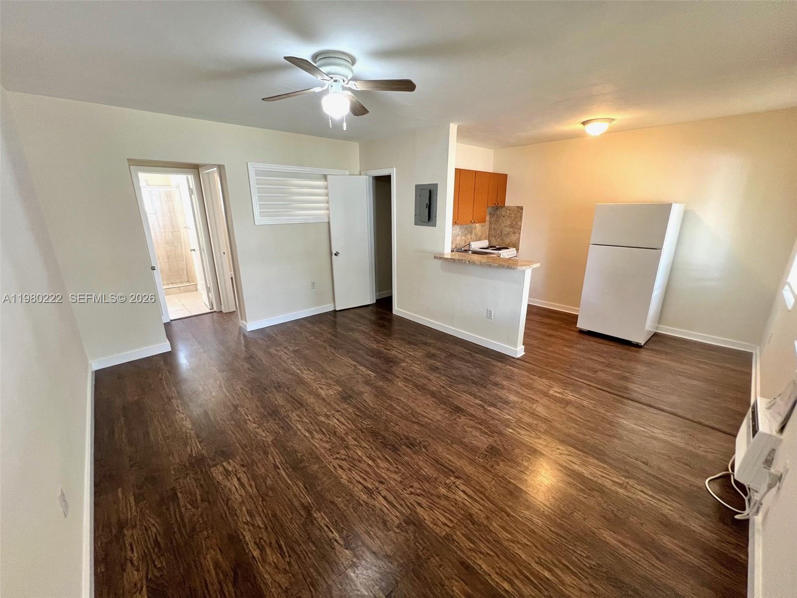 692 Northeast 85th Street, Unit 6 Miami, FL 33138 - Photo 2 of 6 a view of a kitchen with wooden floor and a ceiling fan