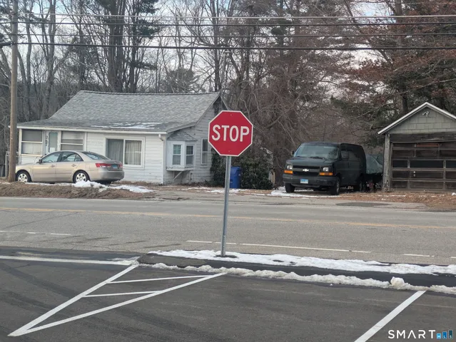 a view of a street with a car parked on the road