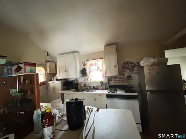a kitchen with stainless steel appliances granite countertop a refrigerator a stove a sink and dishwasher