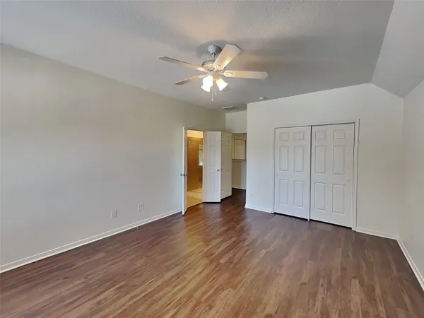 a view of an empty room with wooden floor