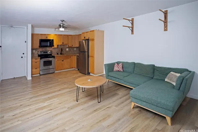 a living room with furniture kitchen and a wooden floor