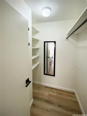 a view of a room with wooden floor and small window