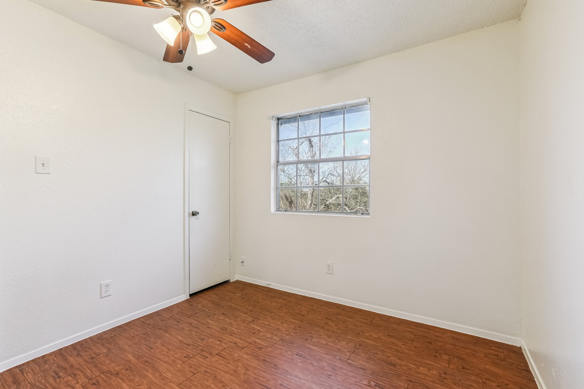 5000 Weidemar Lane, Unit C Austin, TX 78745 - Photo 6 of 8 an empty room with a window and a ceiling fan