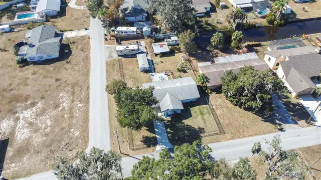 an aerial view of a house with a yard and mountain view in back