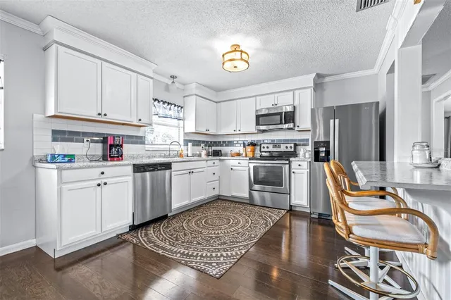 a kitchen with stainless steel appliances granite countertop a refrigerator sink and stove