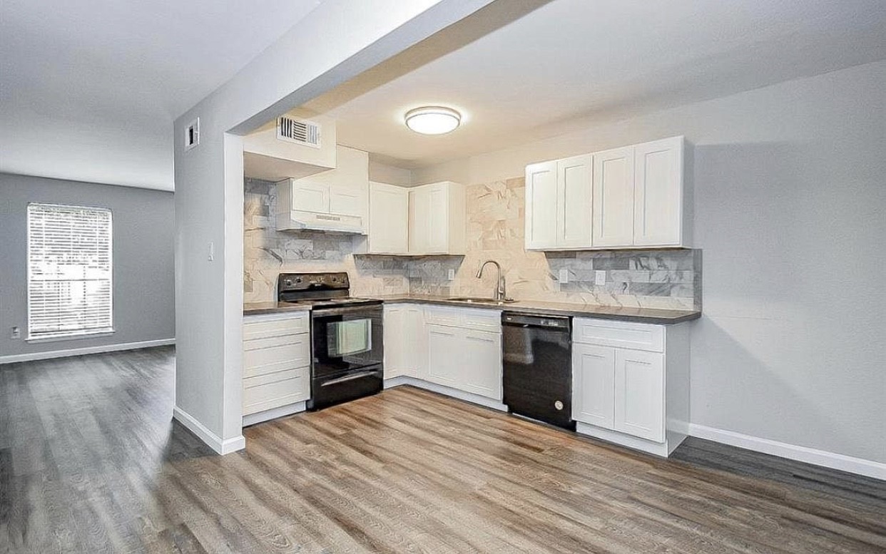 5100 Allendale Road, Unit 306 Houston, TX 77017 - Photo 5 of 13 a kitchen with granite countertop wooden floors stainless steel appliances and sink