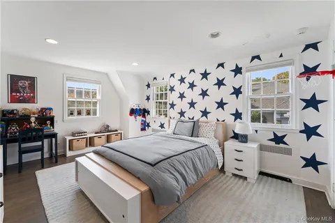 a bedroom with a bed and a flat tv screen on the dresser