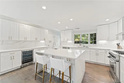 a kitchen with appliances a sink a stove a table and chairs
