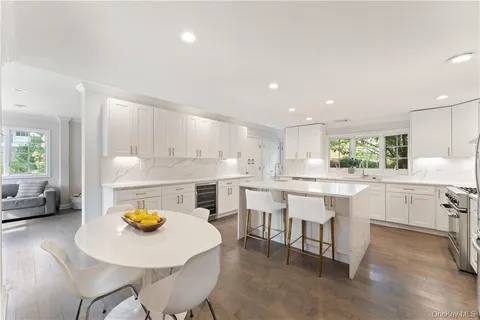 a kitchen with a sink a stove and white cabinets with wooden floor