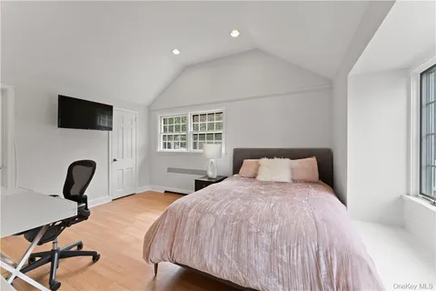 a bedroom with a bed a table and a flat screen tv