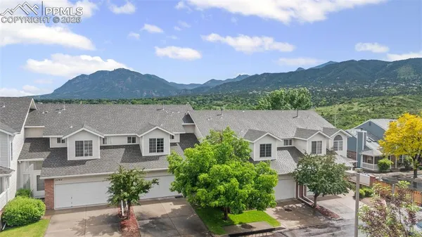 a aerial view of a house with a yard and a large tree