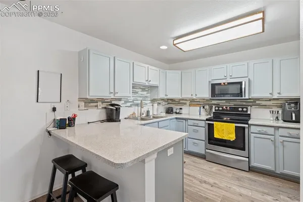 a kitchen with a sink a stove cabinets and a counter top space