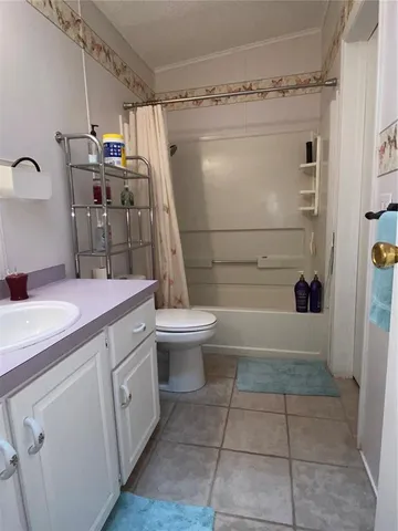 a bedroom with a bed and a lamp on the dresser