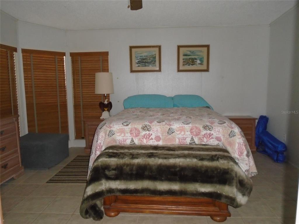 5559 Southwest 42nd Place Bell, FL 32619 - Photo 33 of 48 a bedroom with a bed and a painting on the wall