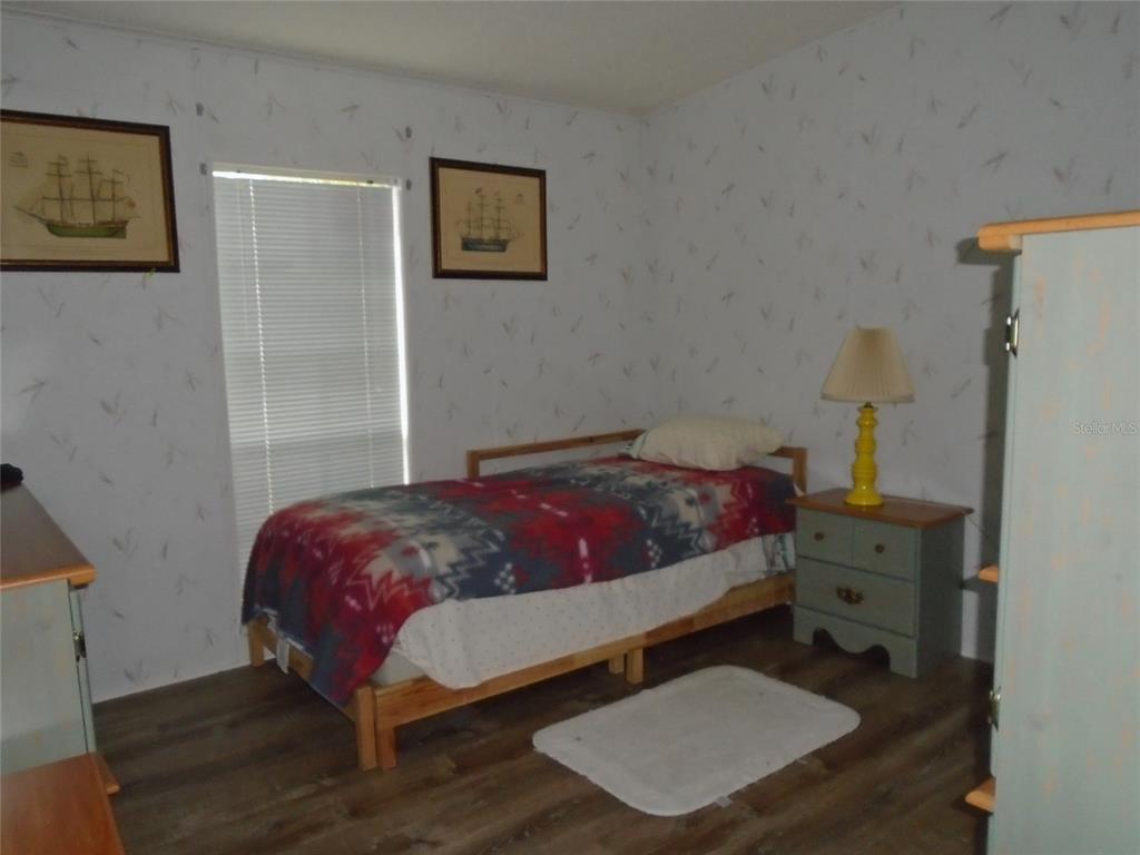 5559 Southwest 42nd Place Bell, FL 32619 - Photo 38 of 48 a bedroom with a bed and a lamp on the dresser
