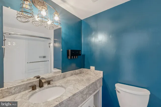 a bathroom with a granite countertop toilet sink and mirror