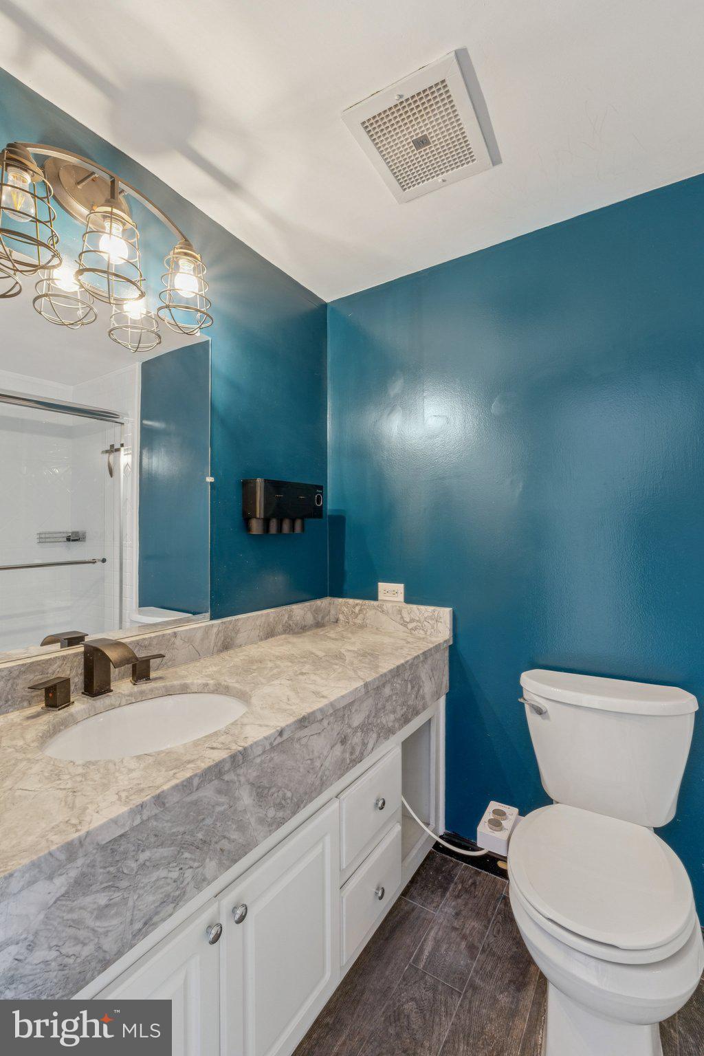 1530 Key Boulevard, Unit 929 Arlington, VA 22209 - Photo 23 of 37 a bathroom with a granite countertop toilet sink and mirror