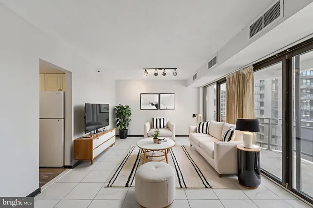 a living room with furniture a large window and a chandelier