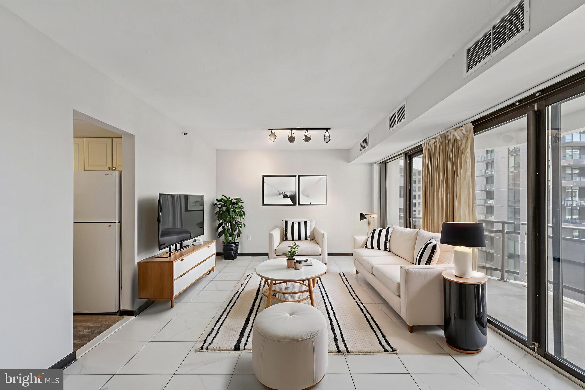 1530 Key Boulevard, Unit 929 Arlington, VA 22209 - Photo 3 of 37 a living room with furniture a large window and a chandelier