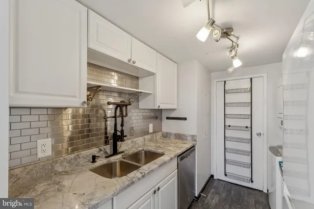 a kitchen with stainless steel appliances granite countertop a sink and a refrigerator