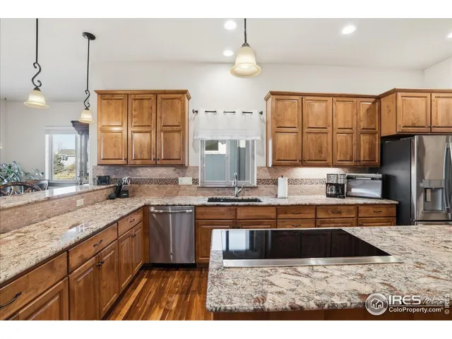 a kitchen with kitchen island granite countertop a sink stainless steel appliances and cabinets