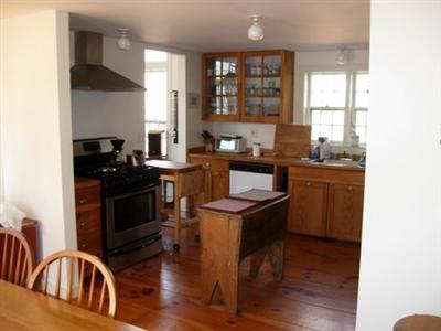 4 Lesser Lane Truro, MA 02666 - Photo 7 of 15 a kitchen with granite countertop a stove a sink a refrigerator and wooden floor