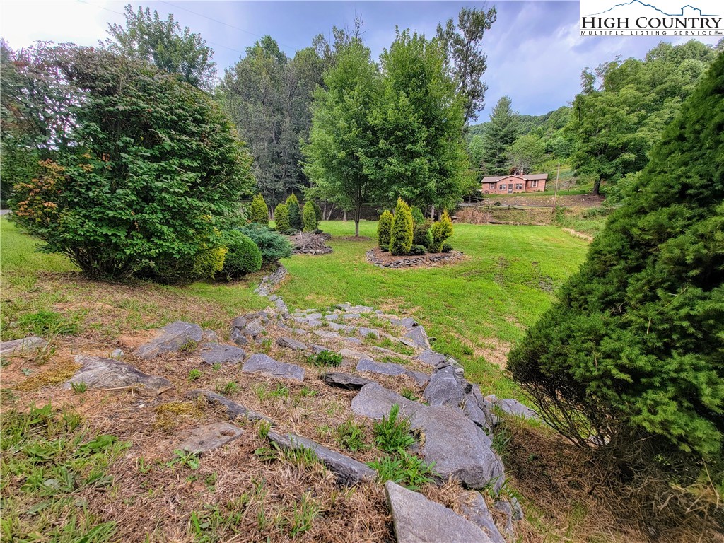 West Mill Creek Road Warrensville, NC 28693 - Photo 10 of 13 a view of a yard with plants and a bench