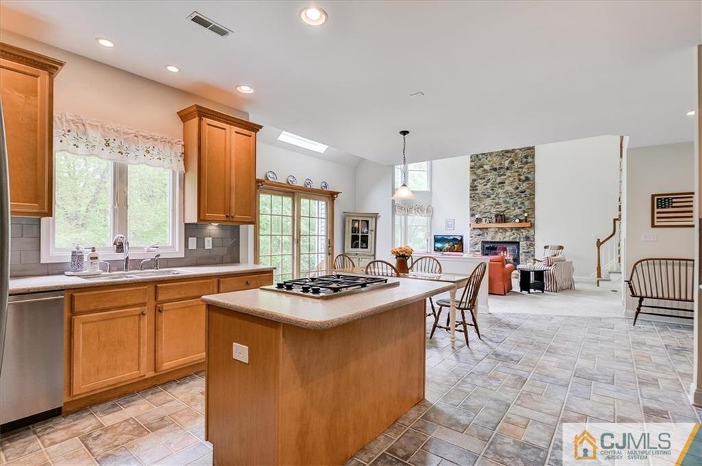 76 Bennett Road Old Bridge, NJ 07747 - Photo 7 of 23 a kitchen with stainless steel appliances granite countertop a stove a sink dishwasher and white cabinets with wooden floor