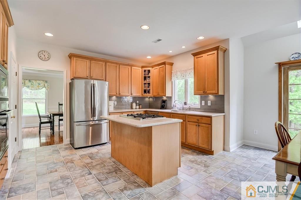 76 Bennett Road Old Bridge, NJ 07747 - Photo 8 of 23 a kitchen with stainless steel appliances granite countertop a refrigerator a sink a stove and white cabinets