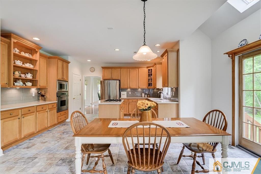76 Bennett Road Old Bridge, NJ 07747 - Photo 9 of 23 a view of a dining room and livingroom with furniture wooden floor a rug a fireplace and a chandelier
