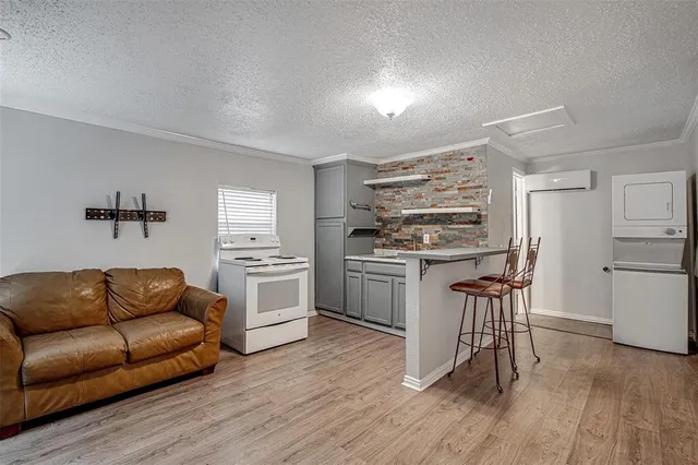 a kitchen with stainless steel appliances a stove a sink dishwasher a refrigerator with white cabinets and wooden floor