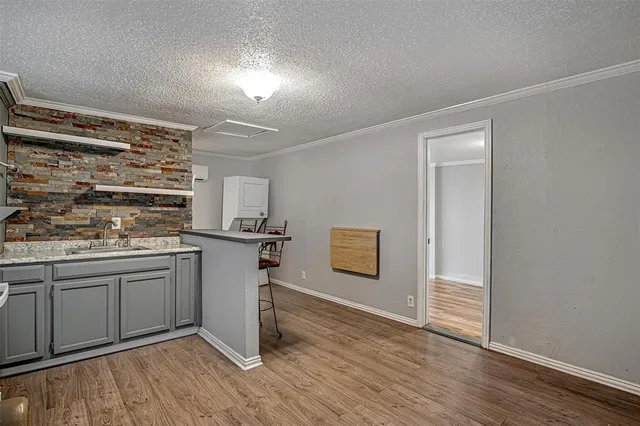 a kitchen with a sink cabinets and wooden floor