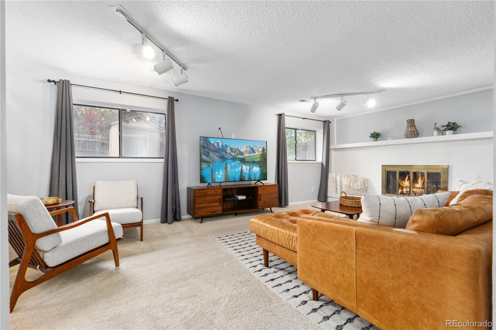 11841 West Dumbarton Drive Morrison, CO 80465 - Photo 14 of 45 a living room with furniture window and a fireplace