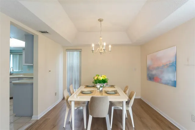 a view of a dining room with furniture a chandelier and wooden floor