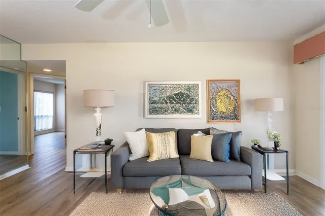 a living room with furniture and a painting on the wall