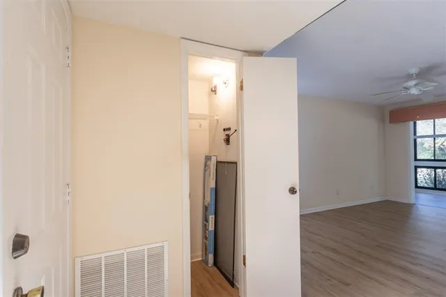 a view of an empty room with wooden floor and a window
