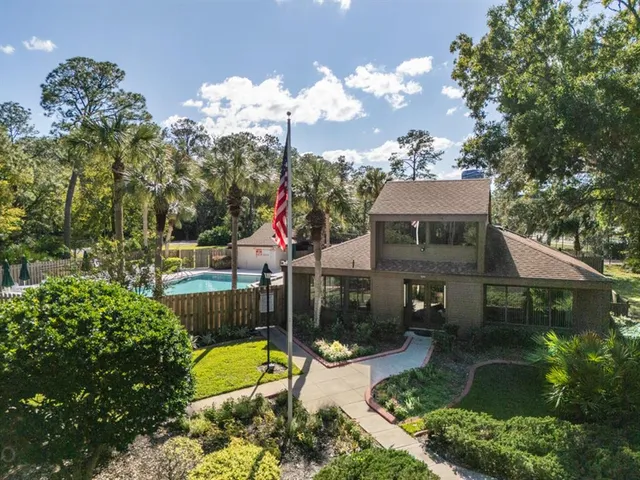 a view of a house with a yard and potted plants