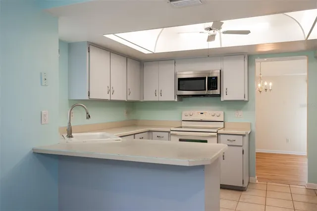 a kitchen with stainless steel appliances granite countertop a sink a stove and cabinets