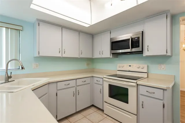 a kitchen with white cabinets appliances and a sink